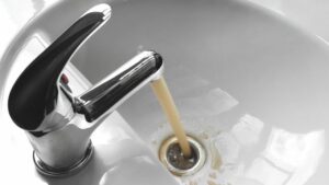 Discolored tap water in sink requiring Houston multi-family plumbing services