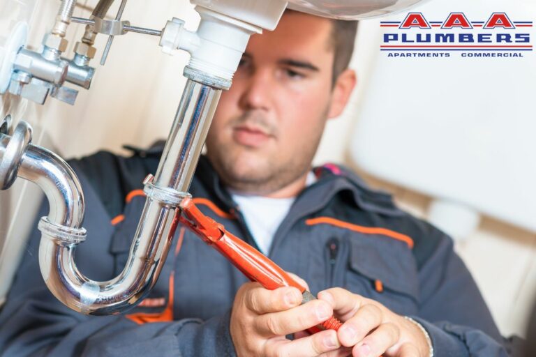 Houston commercial plumber working on P-trap after plumbing emergency
